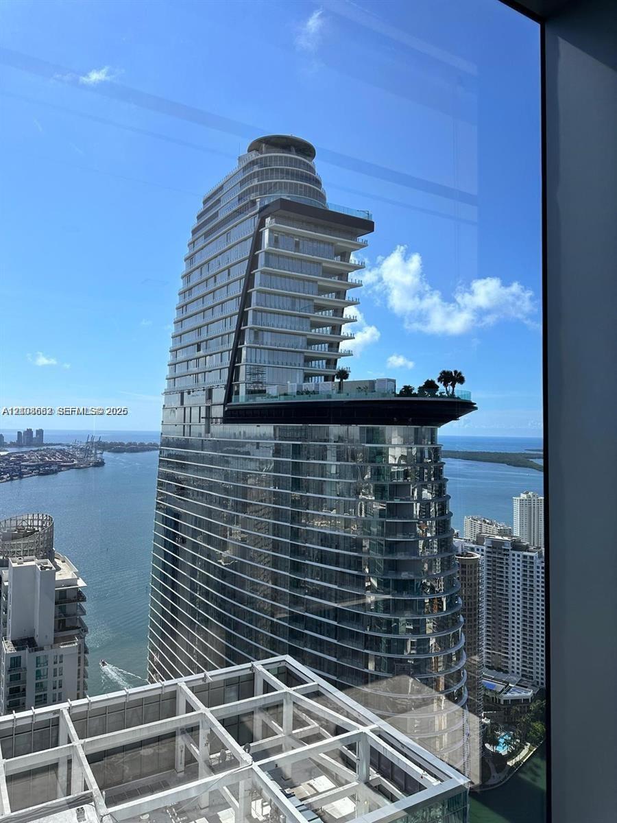 High-rise architectural structure featuring a prominent cantilevered sky deck, expansive glass curtain walls, and a multi-level terrace design