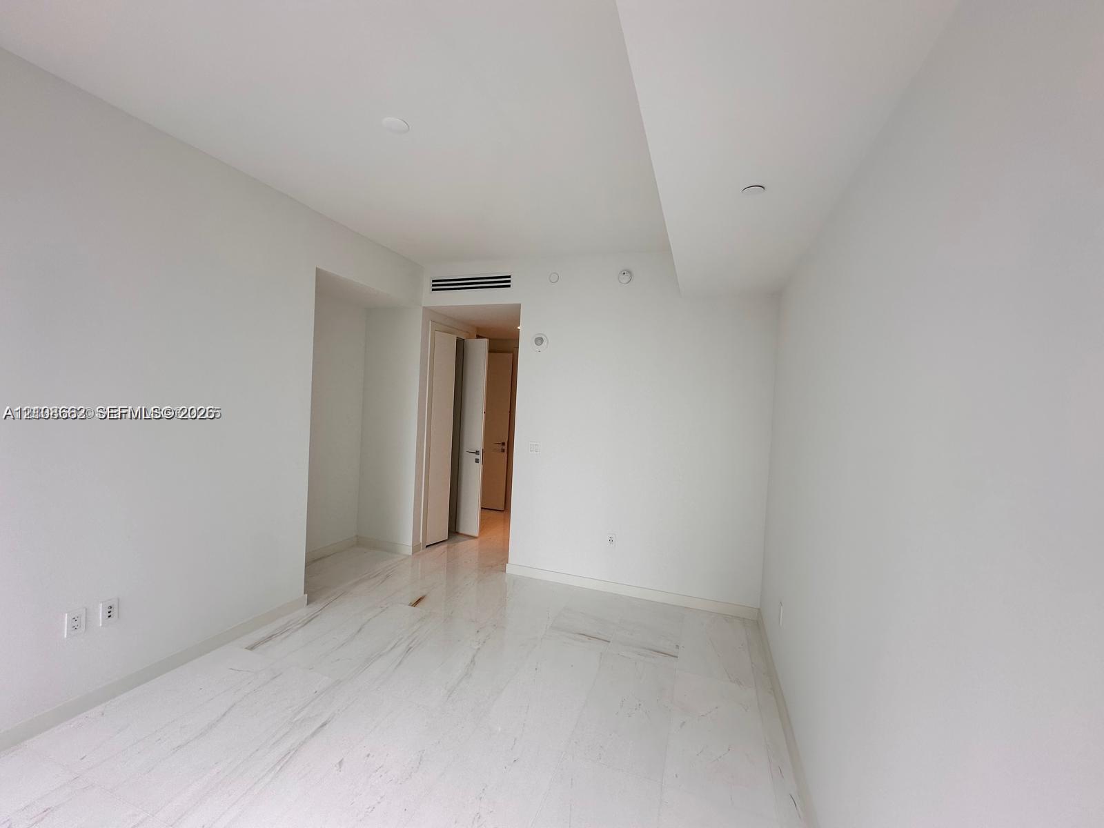 Open interior space featuring polished stone flooring, smooth high ceilings, and recessed lighting