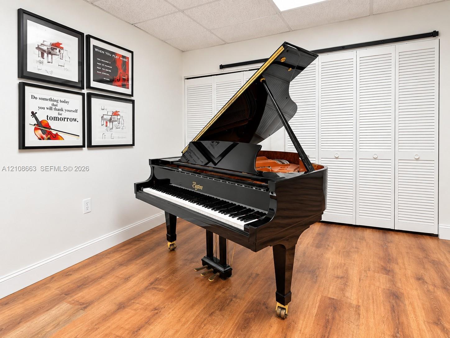 Wood-finish flooring paired with white louvered bifold closet doors and acoustic ceiling tiles Wood-finish flooring paired with white louvered bifold closet doors and acoustic ceiling tiles