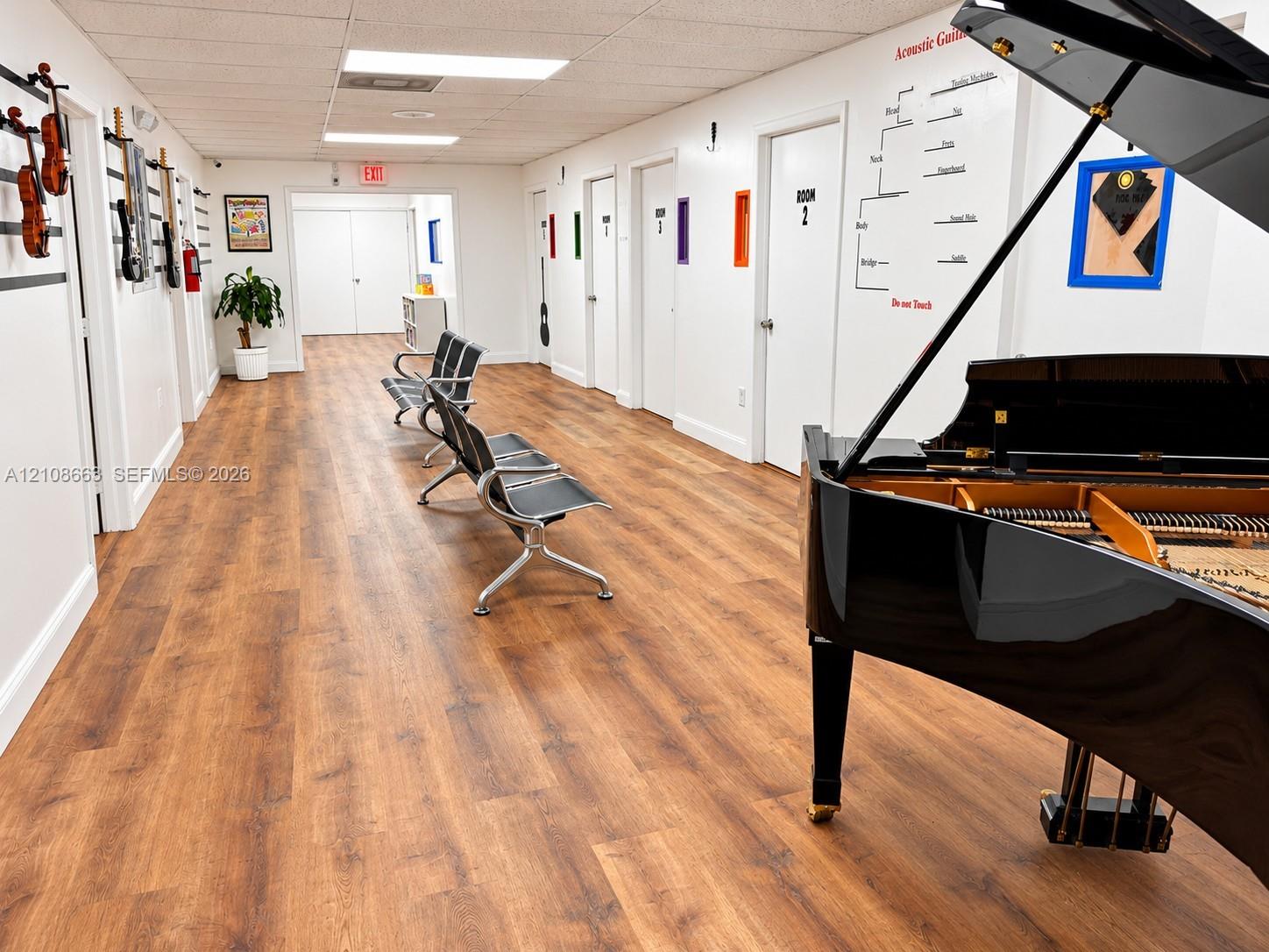 Interior hallway featuring wood-finish flooring, recessed ceiling lighting, and multiple interior access doors