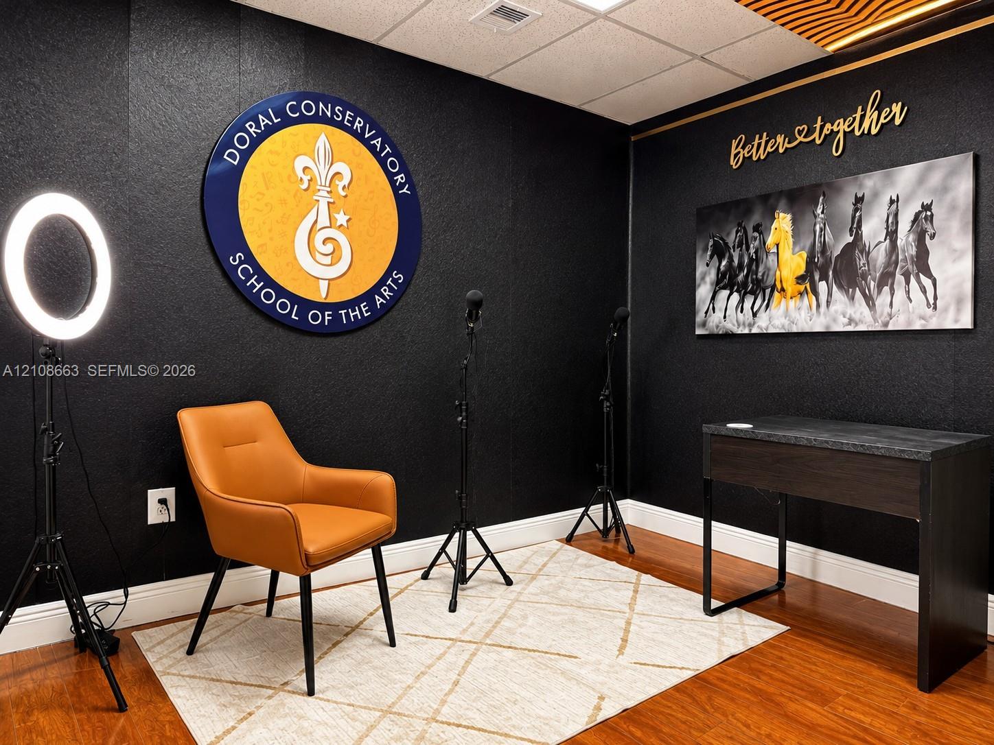 Interior space featuring black textured walls, wood-finish flooring, and recessed ceiling lighting with an integrated decorative slat detail
