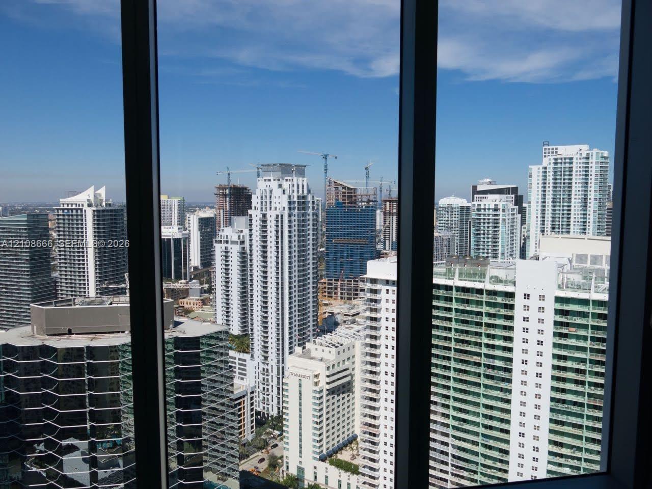 Floor-to-ceiling windows featuring expansive urban skyline exposure Floor-to-ceiling windows featuring expansive urban skyline exposure