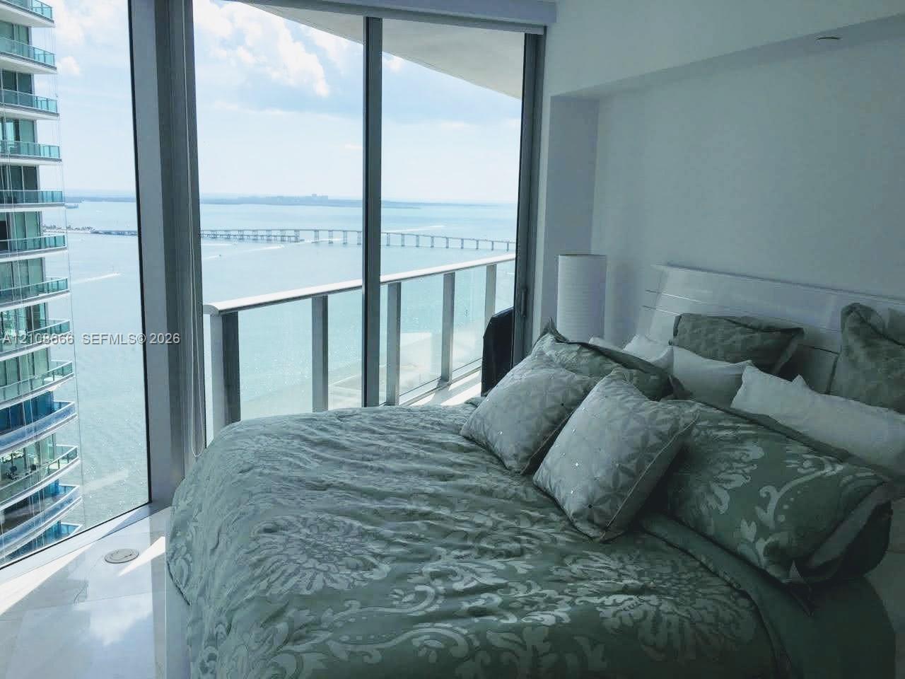 Floor-to-ceiling windows, attached glass-railed balcony, and polished stone flooring Floor-to-ceiling windows, attached glass-railed balcony, and polished stone flooring