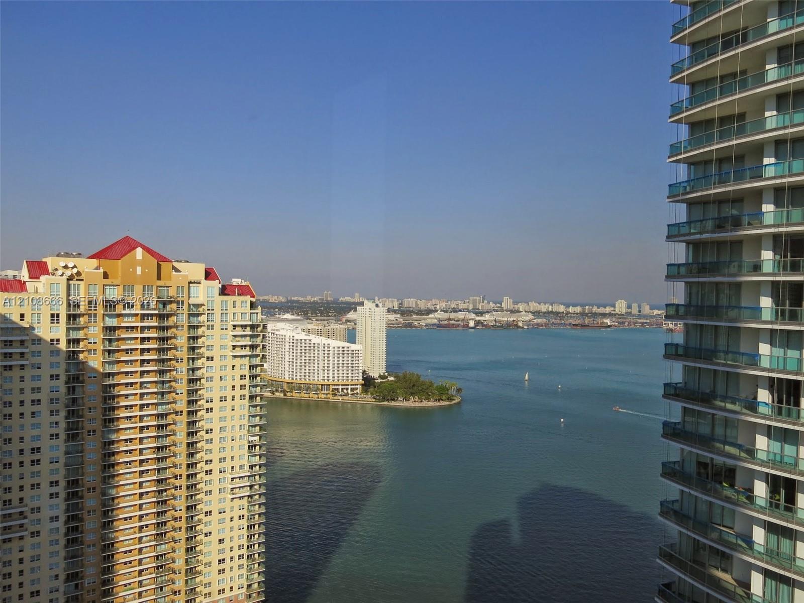 Elevated perspective of the coastal bay and cityscape, featuring expansive water frontage and multi-story high-rise architecture