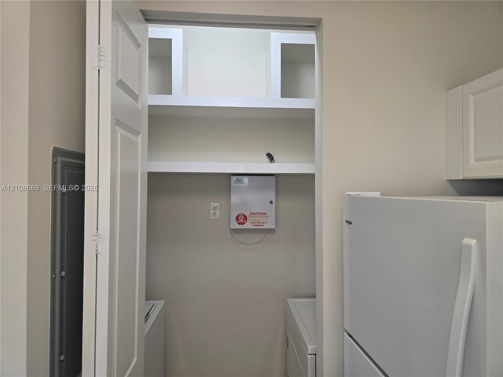 Built-in shelving units and interior closet space featuring solid-core door and neutral finish