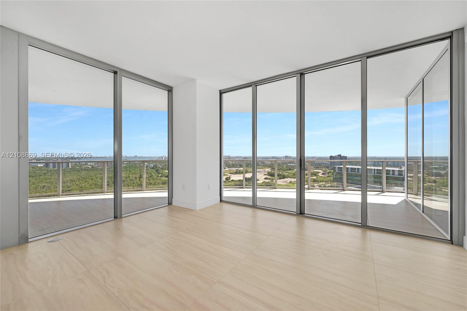 Floor-to-ceiling glass walls, wrap-around balcony, expansive exterior railing, and wood-finish flooring