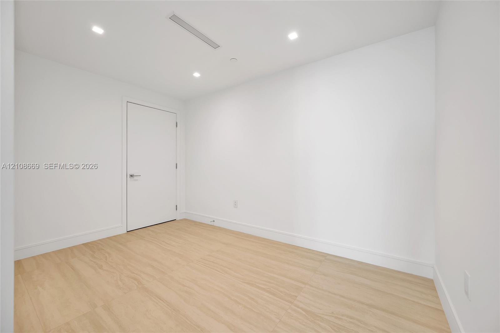 Neutral-toned wood-finish flooring, recessed ceiling lighting, and crisp white wall finishes