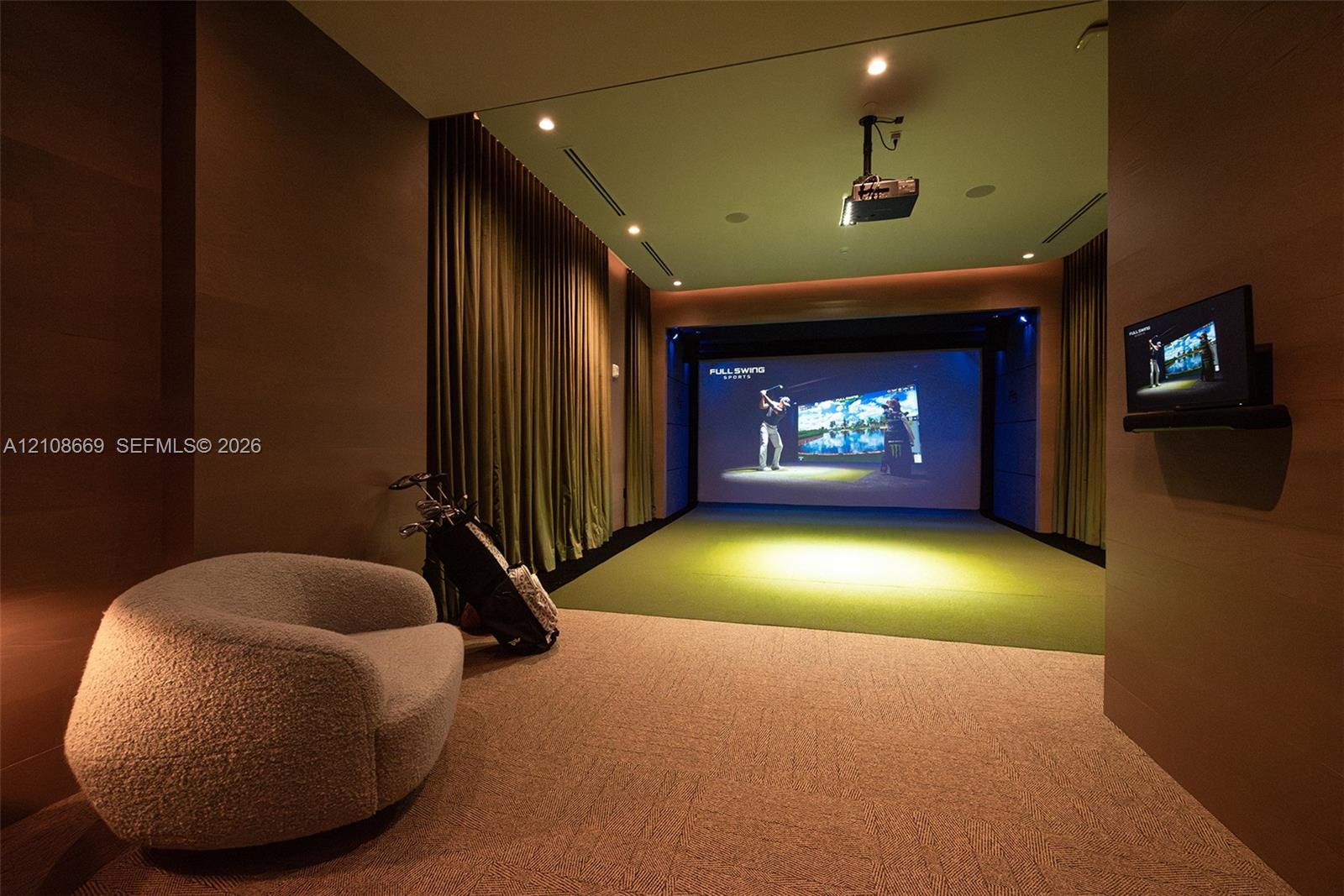 Dedicated recreation room featuring a digital simulator system, recessed ceiling lighting, wall-mounted display, and floor-to-ceiling drapery