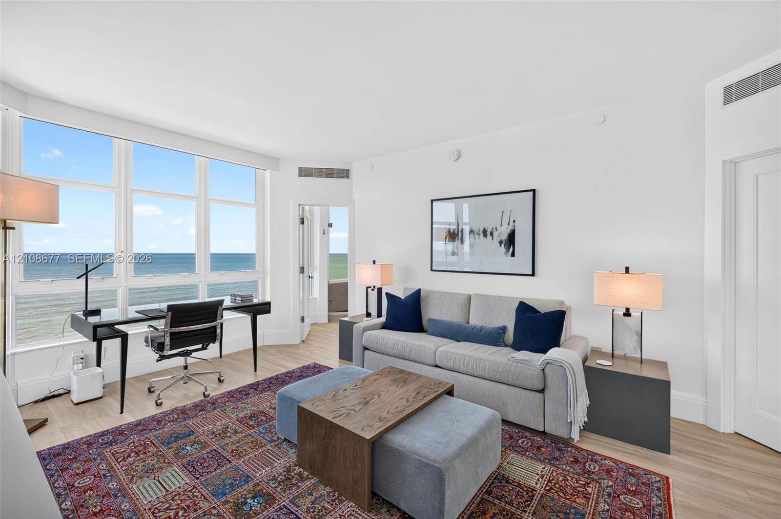 Expansive windows featuring water views, light-toned wood look plank porcelain flooring, and double layered (light filtering and room darkening) remote operated window shades by Bandalux