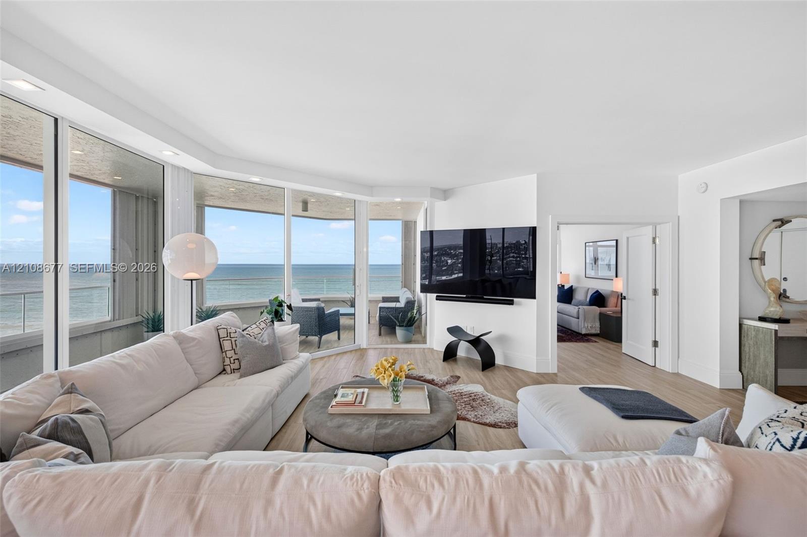 Floor-to-ceiling windows, wood look plank porcelain flooring, recessed lighting, and a private covered balcony. TV wall was expanded to accommodate a larger TV. Light filtering remote operated shades with Bandalux in curtain pocket