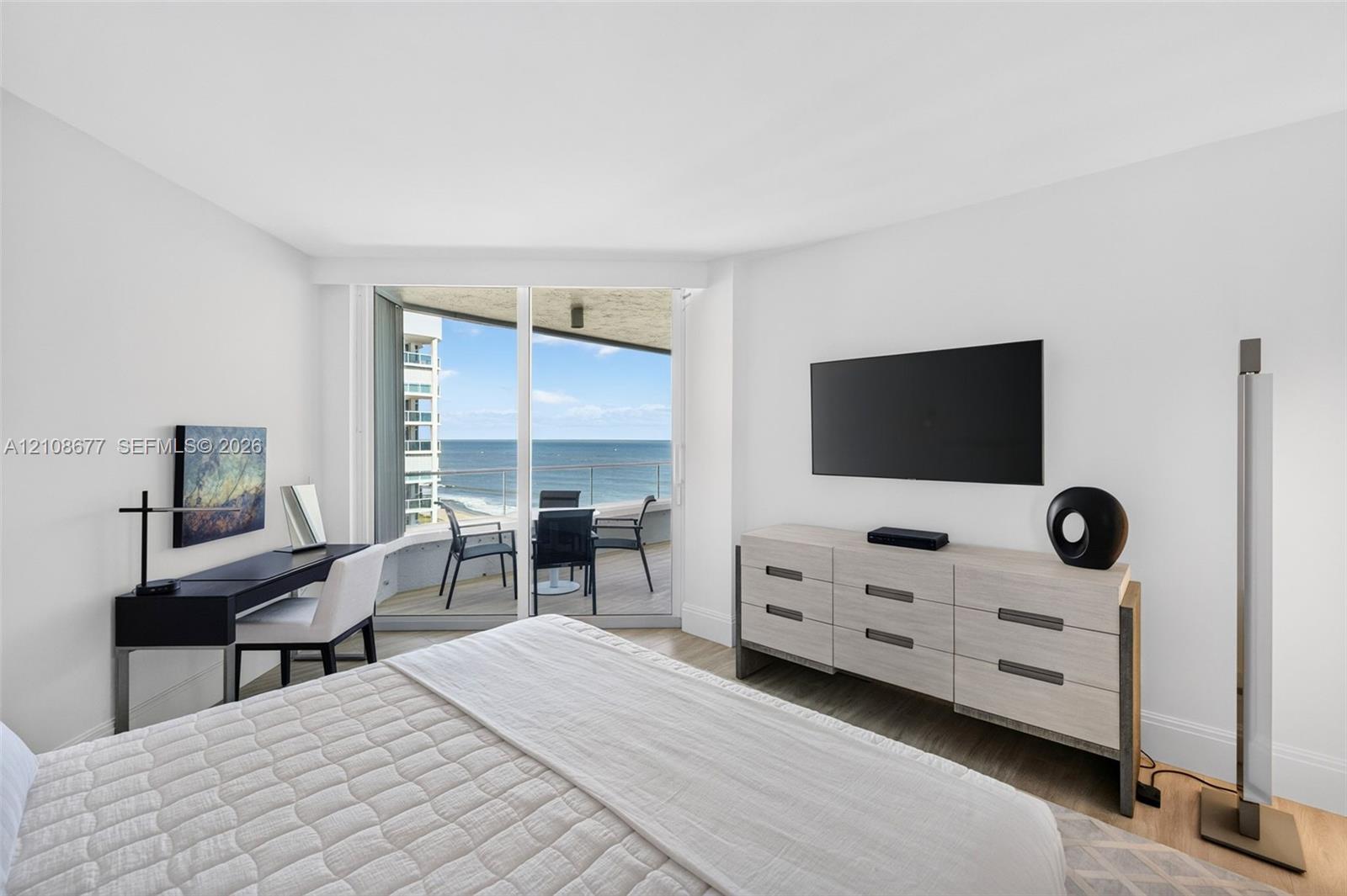 Full-height sliding glass doors opening to a private balcony, wood look plank porcelain flooring, and expansive ocean views. Double layered (light filtering and room darkening) remote operated window shades by Bandalux Full-height sliding glass doors opening to a private balcony, wood look plank porcelain flooring, and expansive ocean views. Double layered (light filtering and room darkening) remote operated window shades by Bandalux