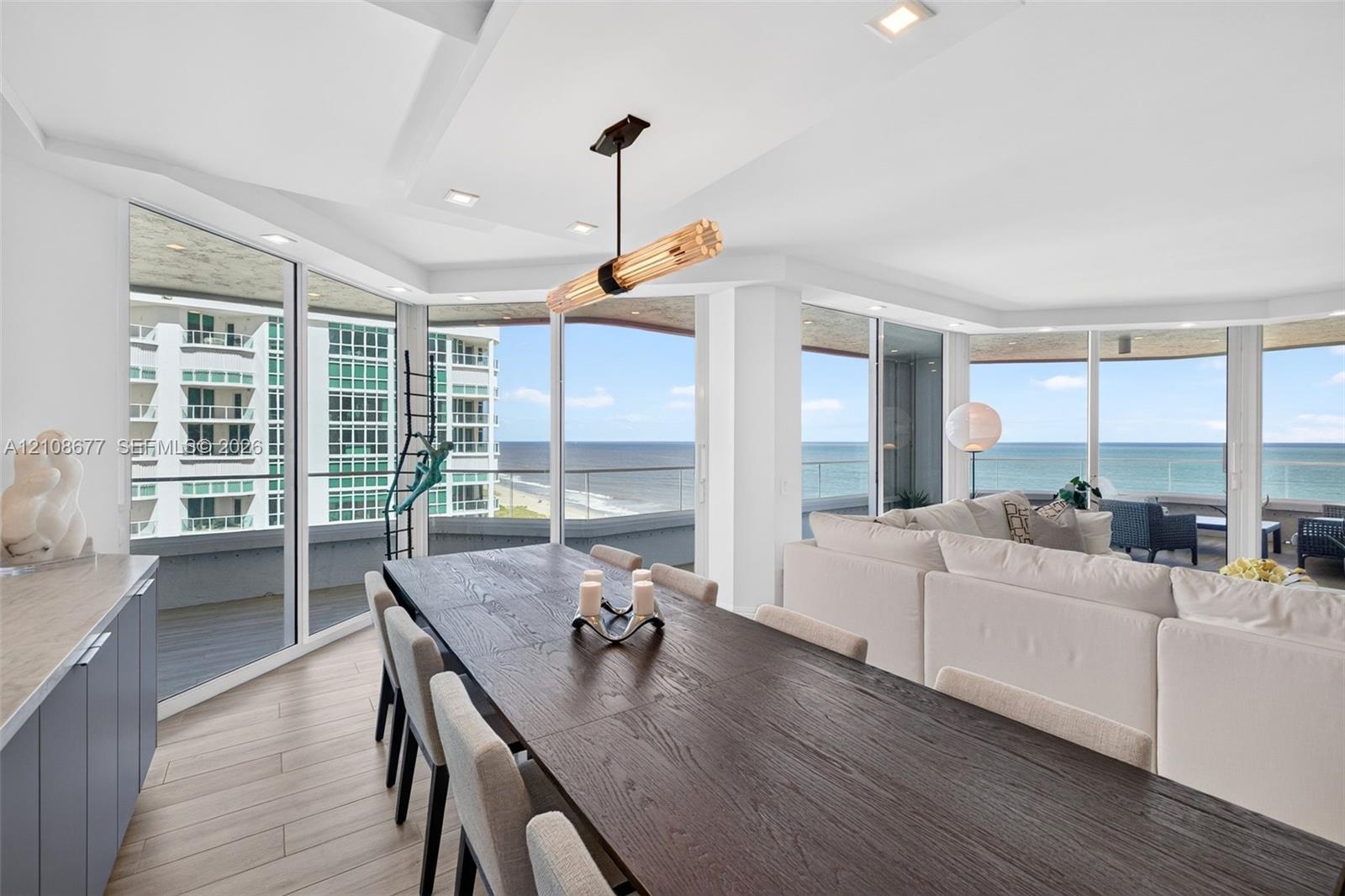 Floor-to-ceiling impact windows, wide-plank tile flooring, recessed lighting, contemporary linear light fixture, and wrap-around exterior balcony with glass railing for endless ocean views from your large formal dining area. Light filtering remote operated shades with Bandalux