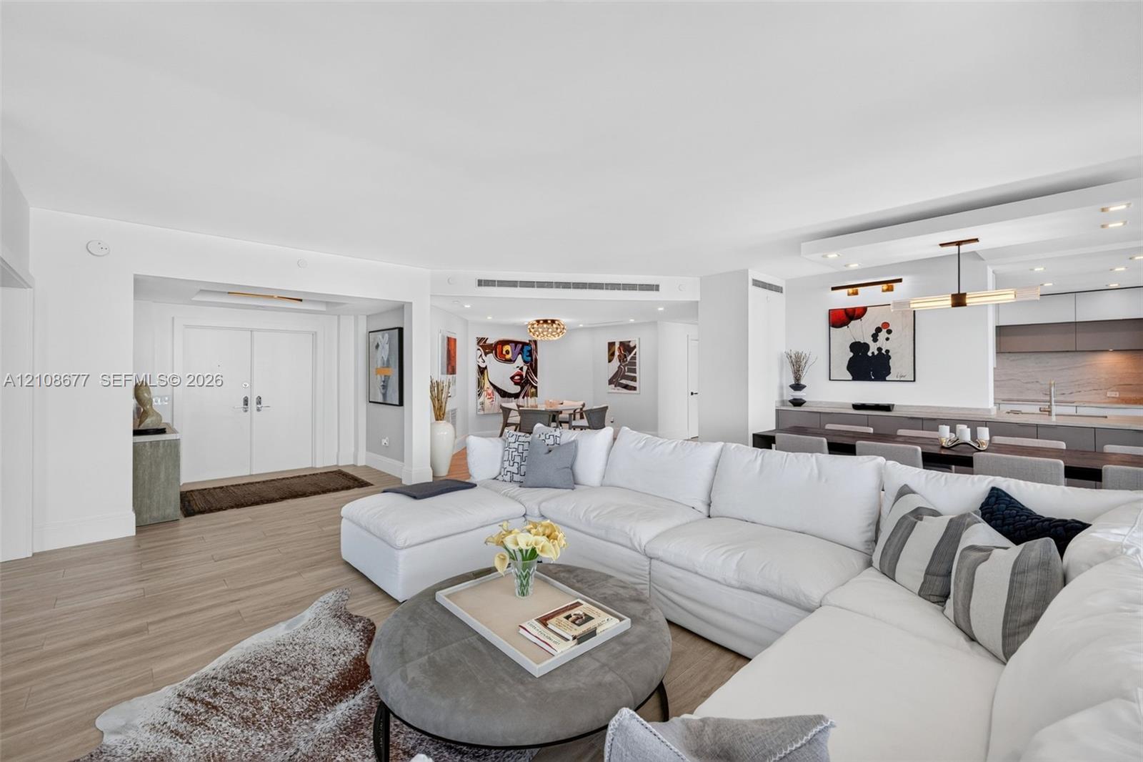 Open floor plan featuring wood look plank porcelain flooring, recessed lighting, double-door entry / foyer, and view toward the kitchen and stone wall backsplash