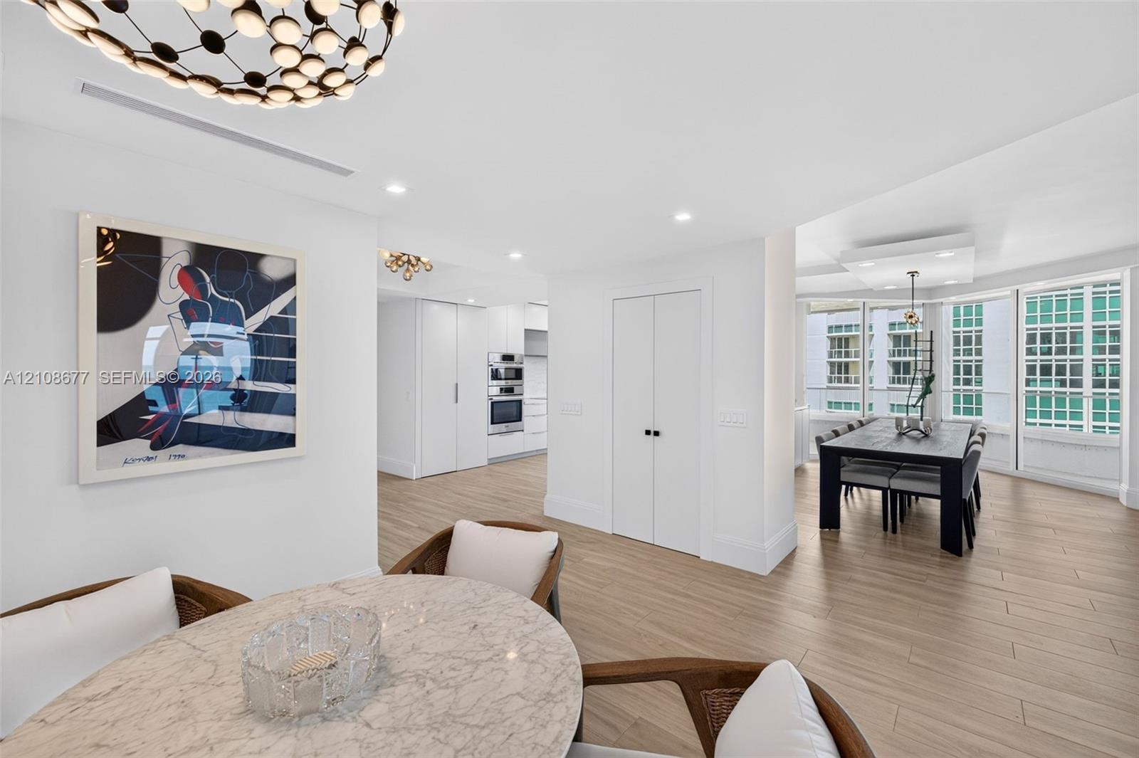 Wood look plank porcelain flooring, recessed lighting, double-door closet / pantry storage, built-in double wall oven, and floor to ceiling windows / sliders from dining area