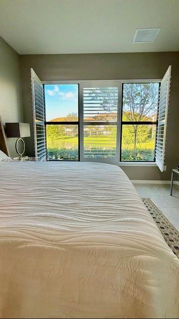 Large multi-pane window with white plantation shutters and water scenery