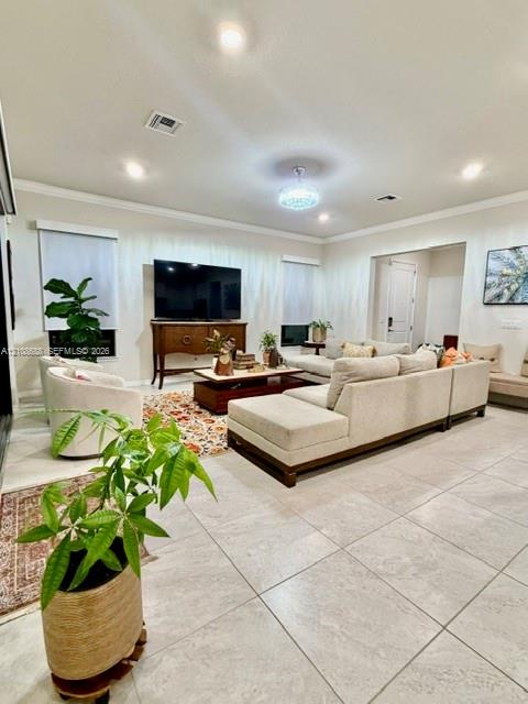 Neutral-toned large-format tile flooring, recessed ceiling lighting, crown molding, and a crystal-accented chandelier
