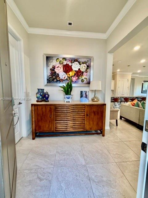Foyer featuring neutral large-format tile flooring, crown molding, and recessed lighting