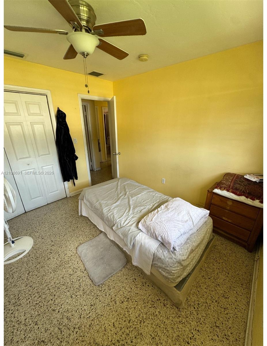 Interior space featuring terrazzo flooring, ceiling-mounted fan with integrated lighting, and dual-panel closet doors