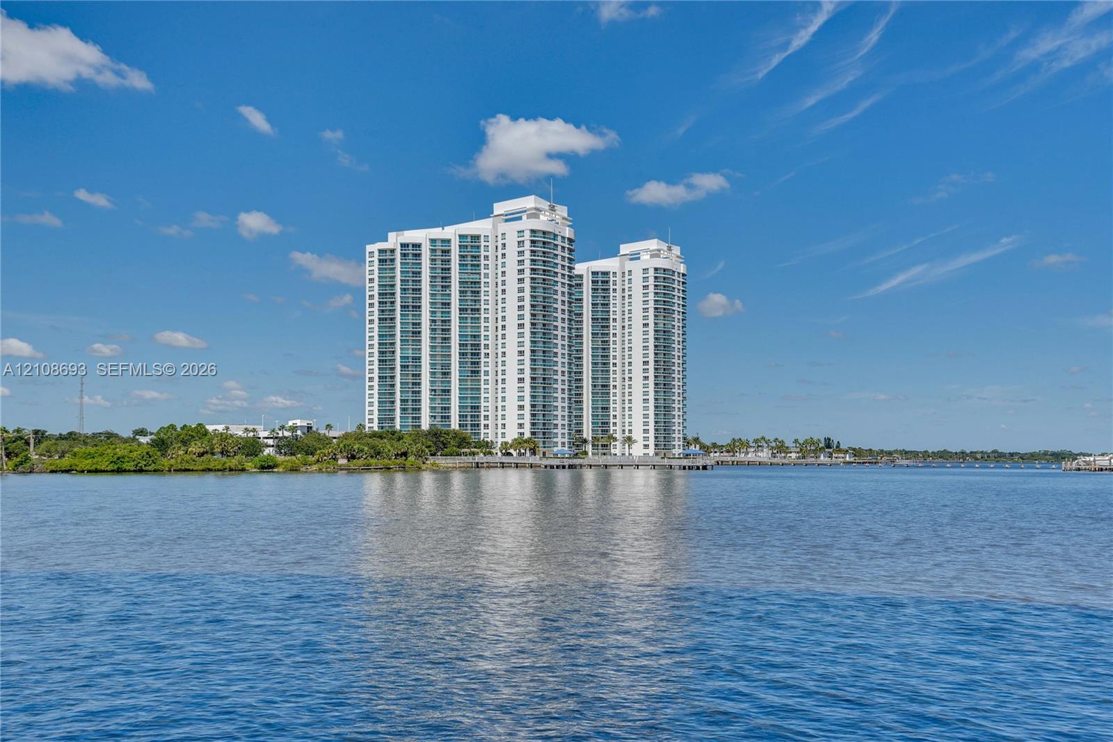 High-rise residential towers featuring expansive glass curtain walls, white structural exterior finish, and direct waterfront positioning