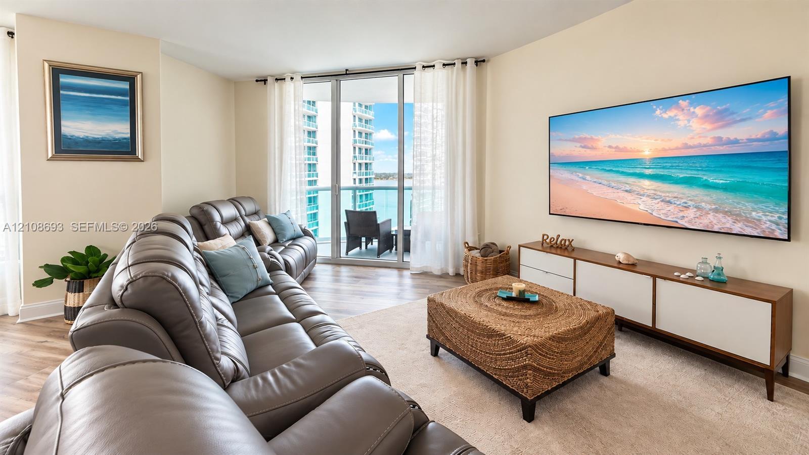 Floor-to-ceiling glass sliding doors, wood-finish flooring, and expansive water backdrop