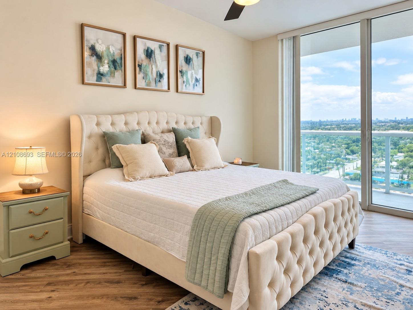 Floor-to-ceiling glass sliding doors, wood-finish flooring, and a ceiling-mounted light fixture with fan