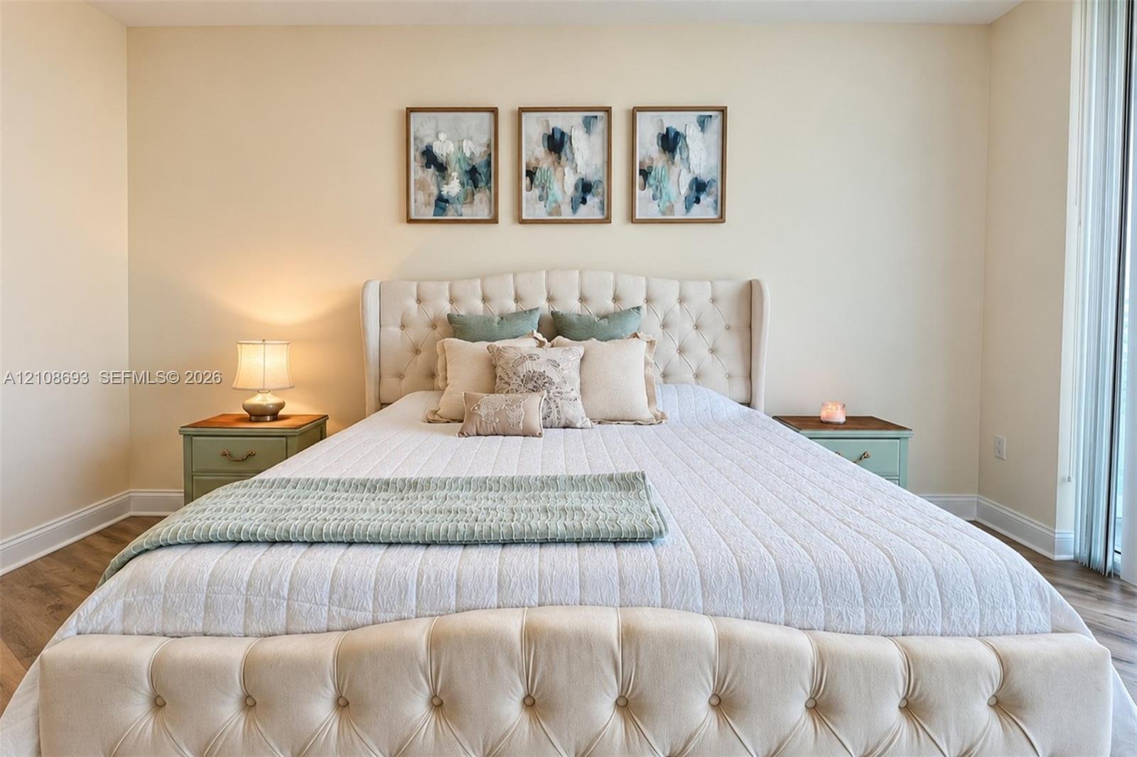 Room featuring wood-finish flooring and floor-to-ceiling glass panel door