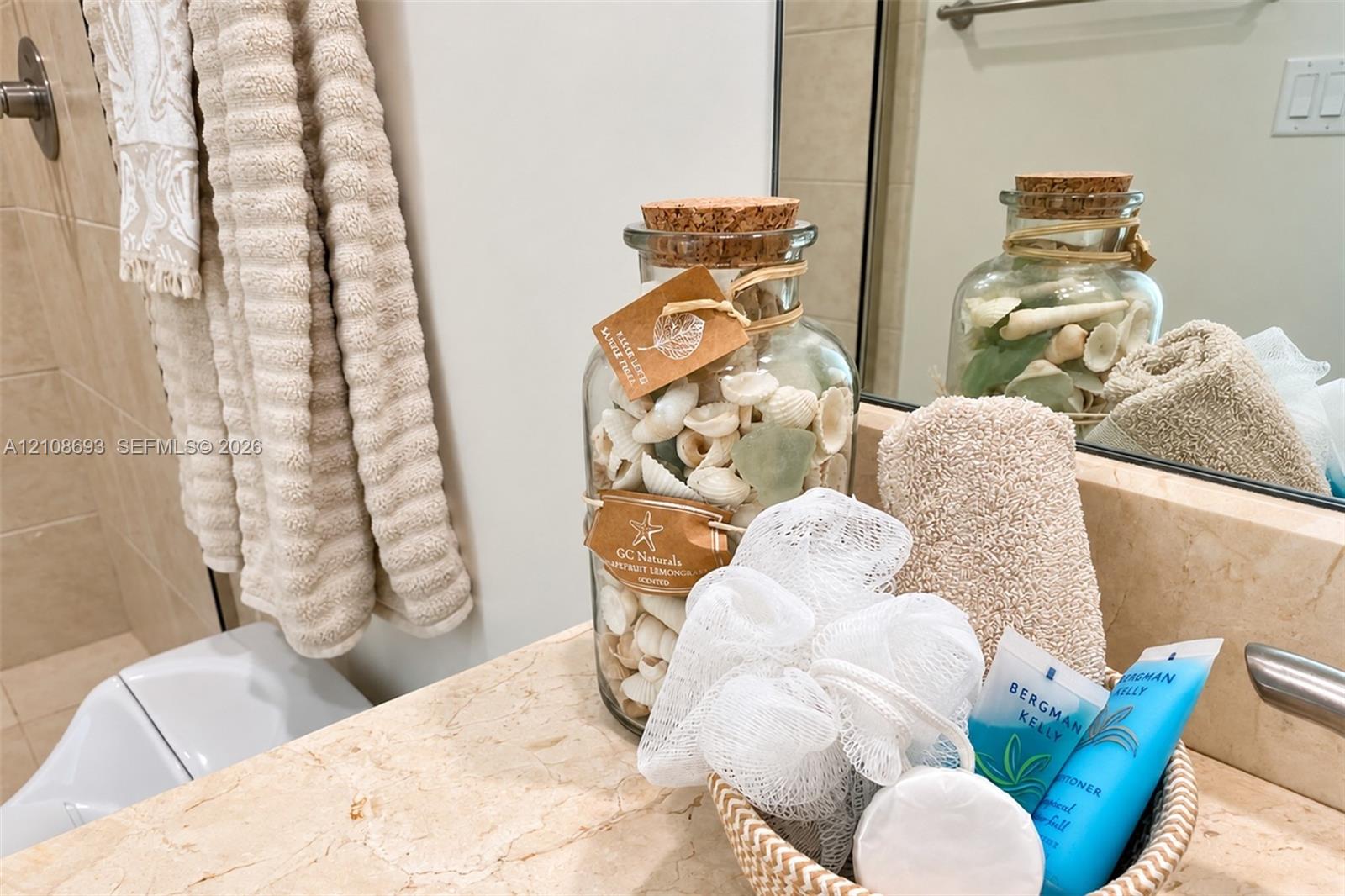 Natural stone vanity countertop with an integrated backsplash and wall-mounted vanity mirror