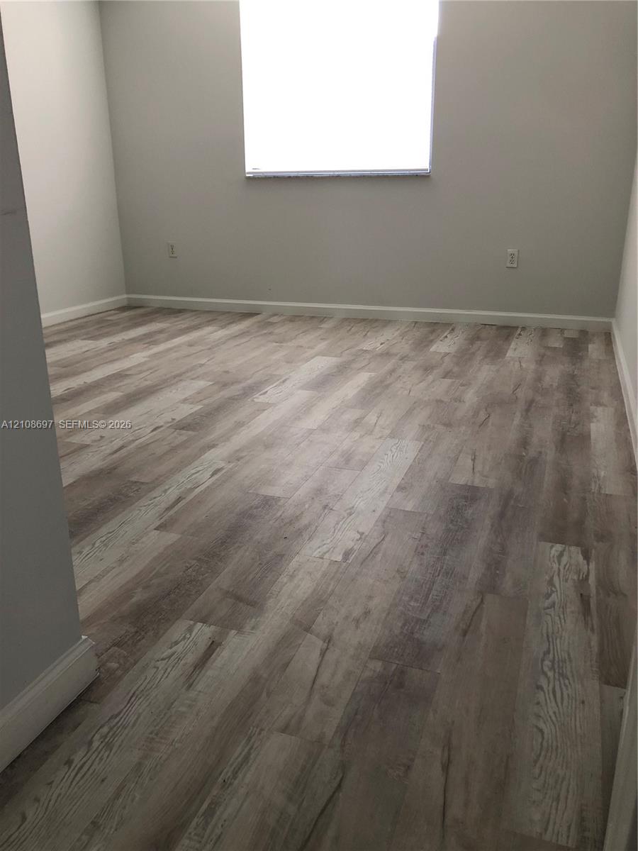 Interior space featuring wood-finish flooring and neutral-toned wall paint