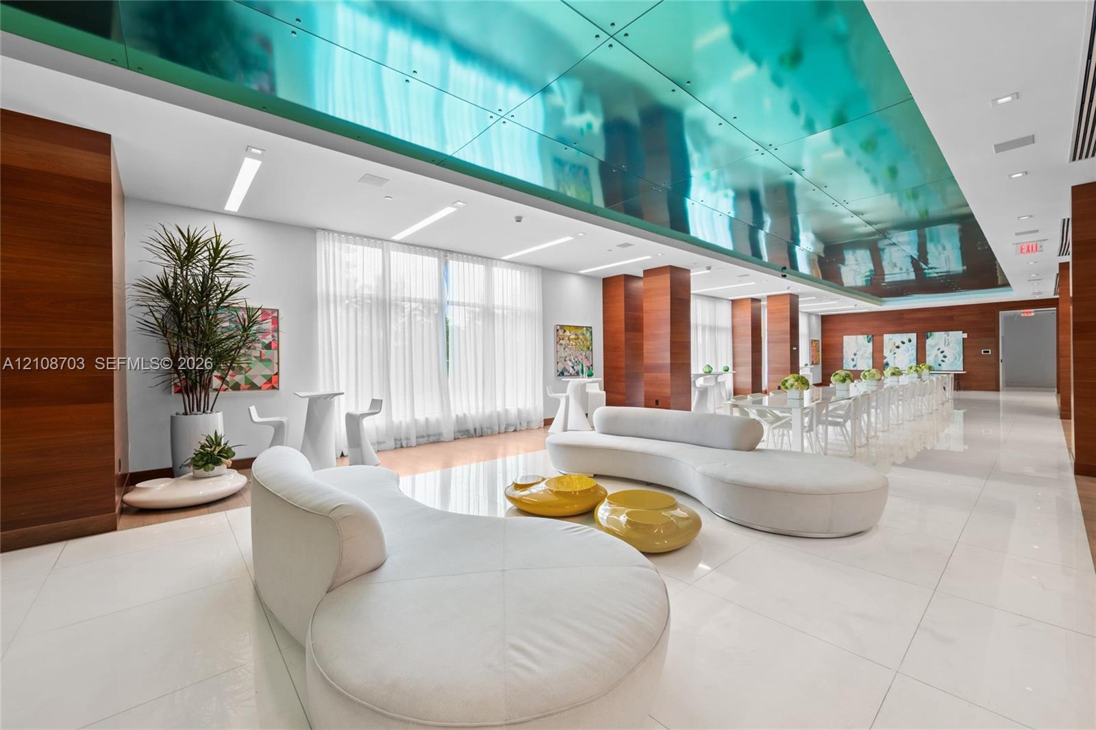 Expansive interior featuring a high-gloss reflective ceiling, wood-paneled support columns, polished tile flooring, and floor-to-ceiling windows with integrated drapery