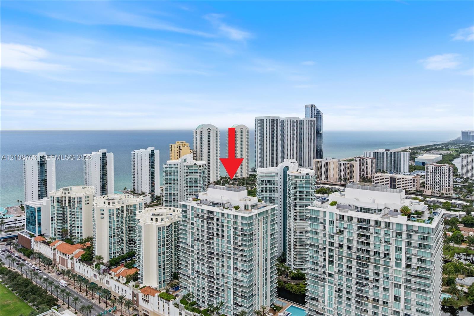 High-rise residential building featuring expansive glass balconies and coastal surroundings