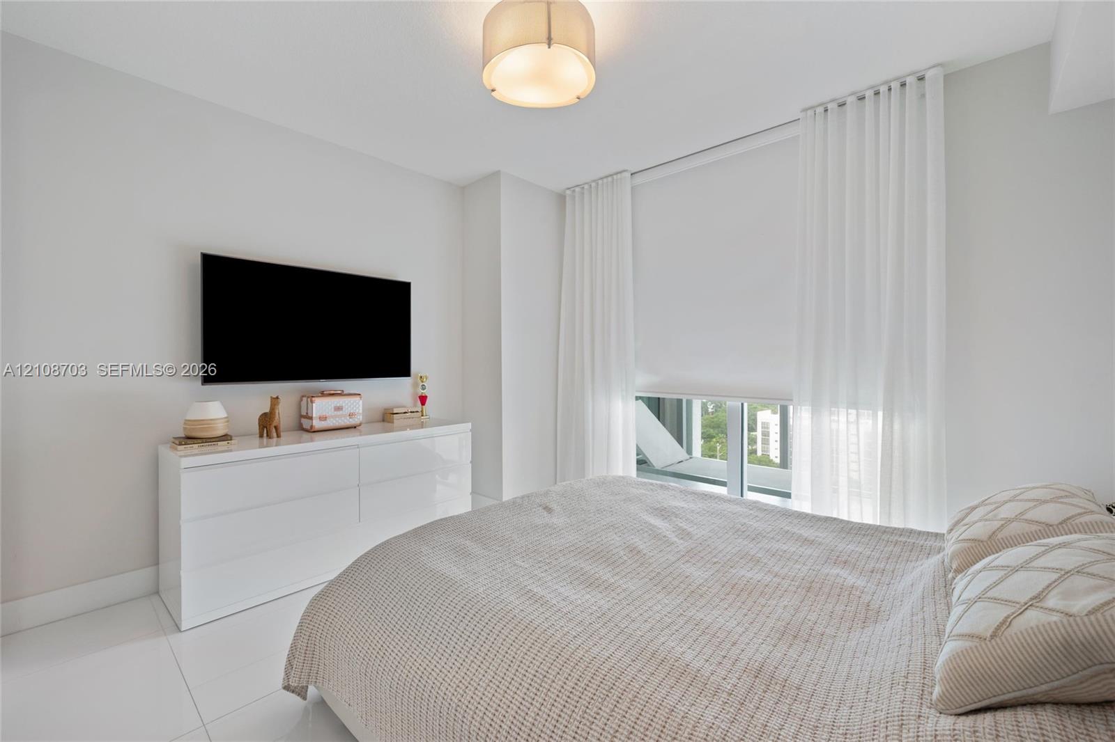 Neutral interior featuring floor-to-ceiling windows, polished tile flooring, and a flush-mount drum ceiling light