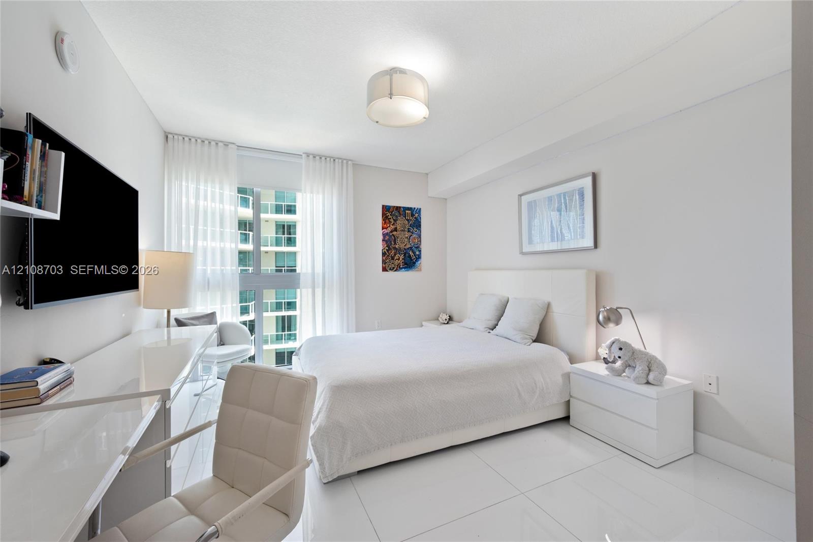 Large-format tile flooring, ceiling-mounted drum light fixture, and floor-to-ceiling glass panel windows