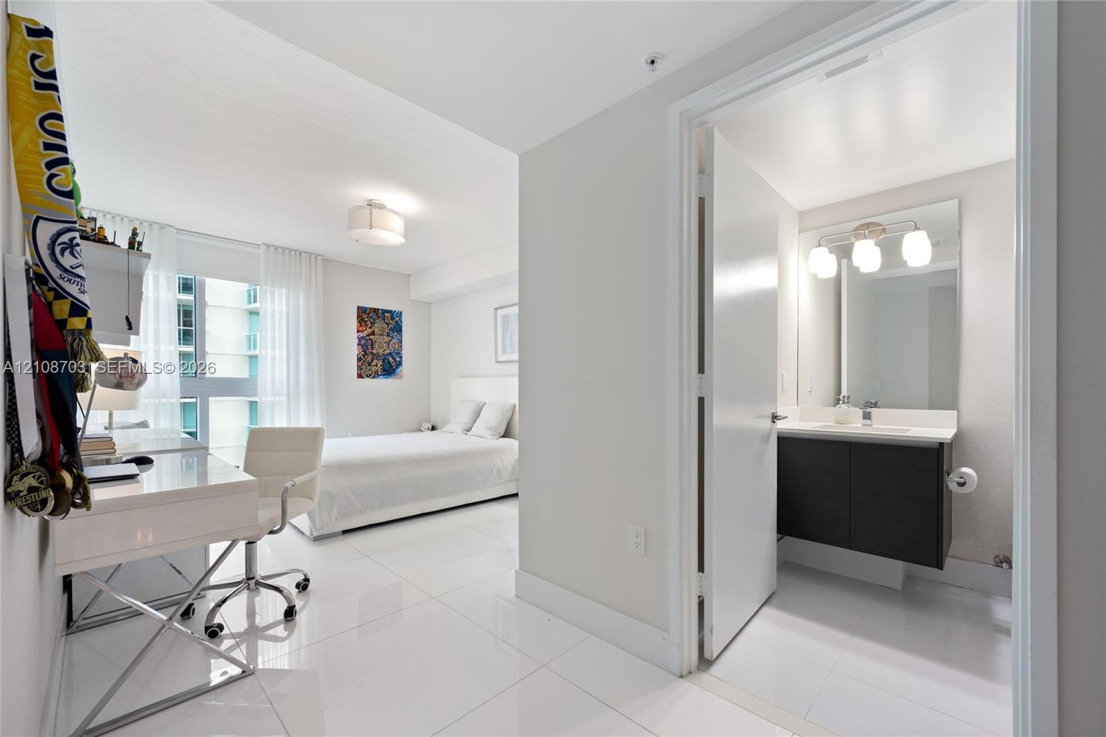 Large-format tile flooring, modern floating vanity with a single basin, frameless wall mirror, and floor-to-ceiling windows