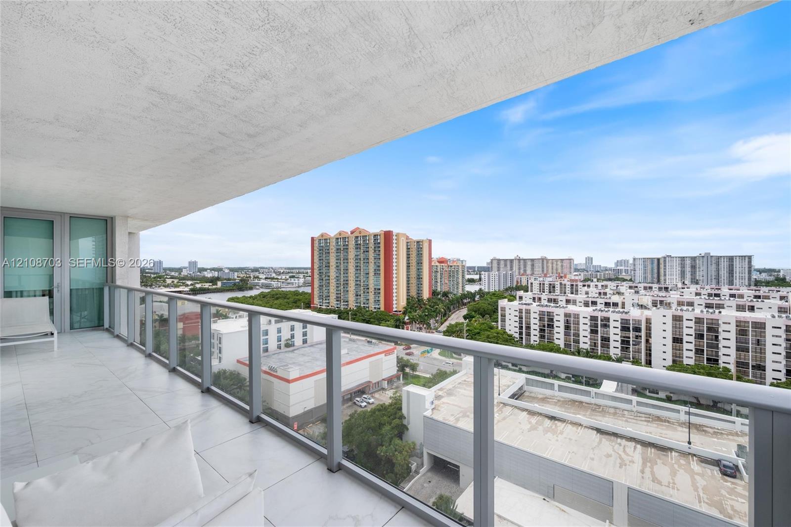 Covered balcony with large-format tile flooring and a glass-paneled railing