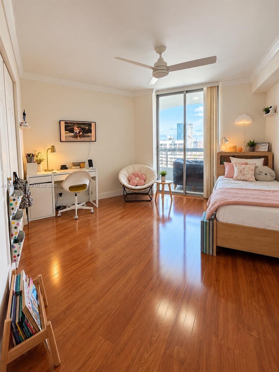 Room featuring wood-finish flooring, a ceiling fan, and sliding glass doors with exterior access