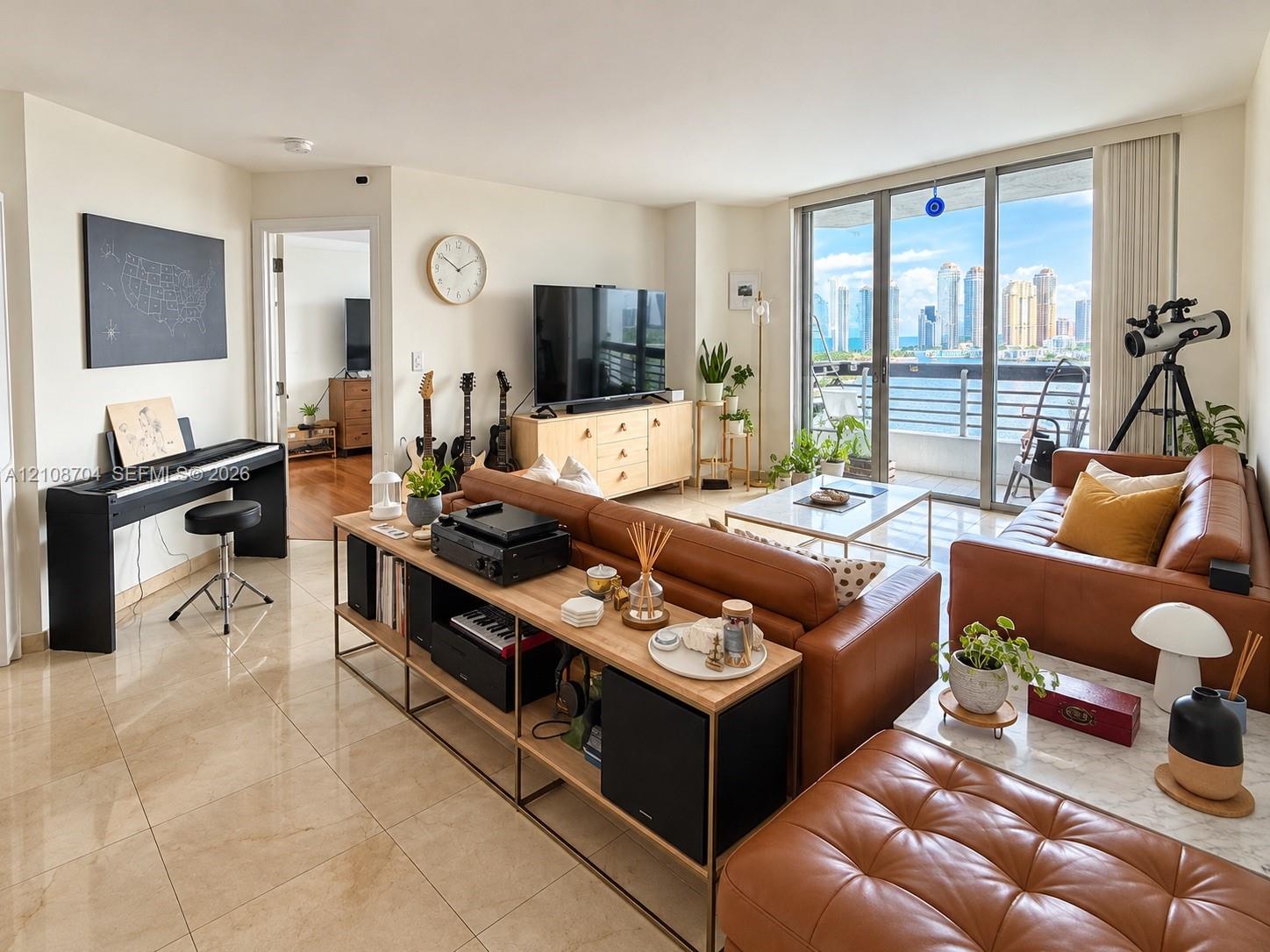 Open-concept living space featuring polished tile flooring, floor-to-ceiling glass sliding doors, and a private balcony Open-concept living space featuring polished tile flooring, floor-to-ceiling glass sliding doors, and a private balcony
