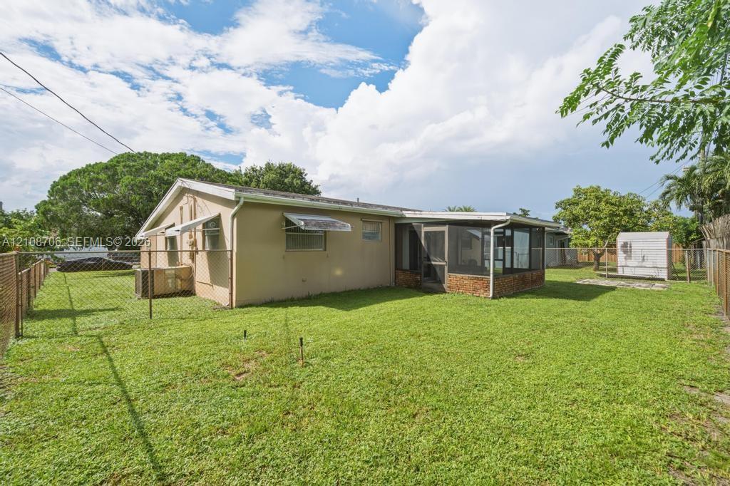 Expansive backyard featuring a fenced perimeter, a screened-in patio, and mature landscaping