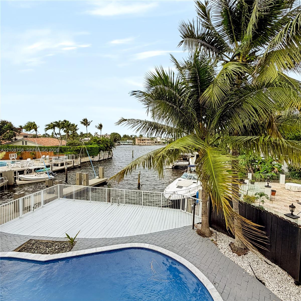 Balcony view over the pool, private dock and wide canal Balcony view over the pool, private dock and wide canal