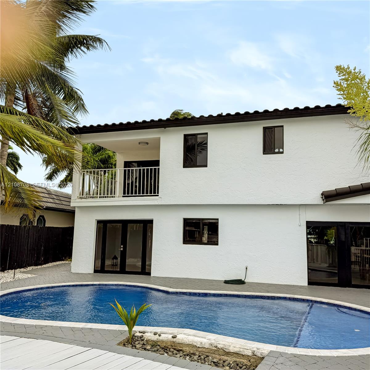 Back of the home with balcony overlooking the pool