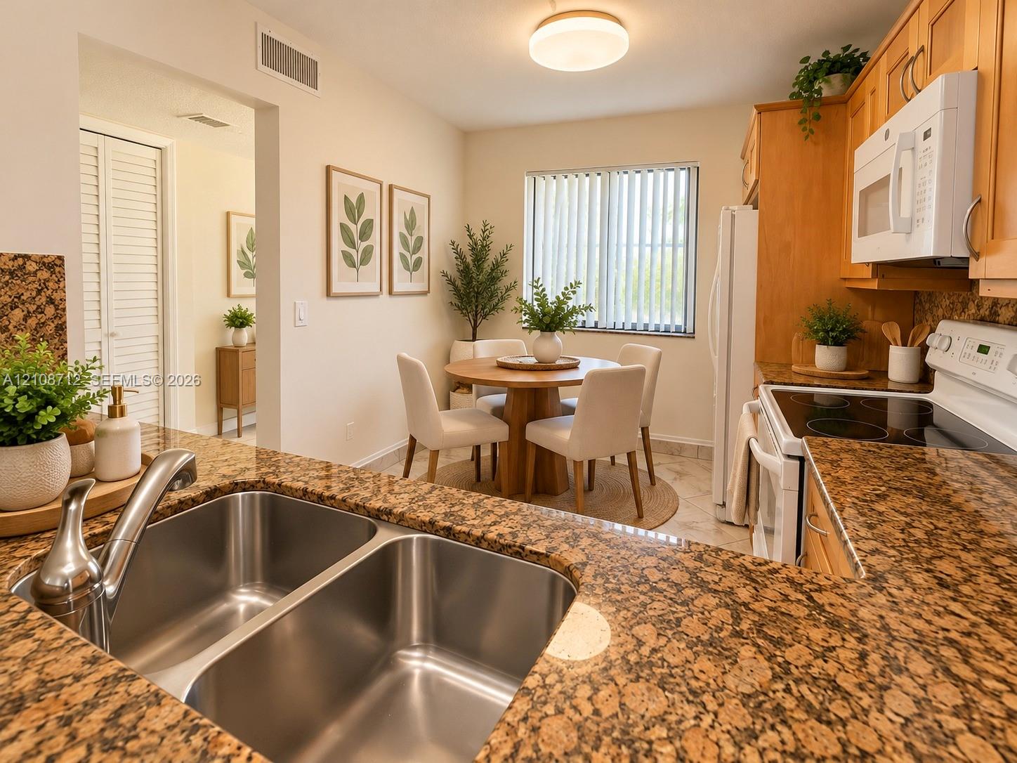 Stage Kitchen featuring granite countertops, double-basin stainless steel sink with high-arc faucet, natural wood cabinetry, and tile flooring