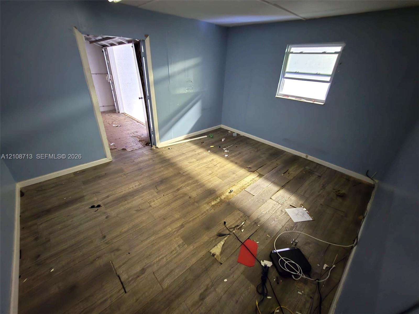 Interior room featuring wood-finish flooring and a single window