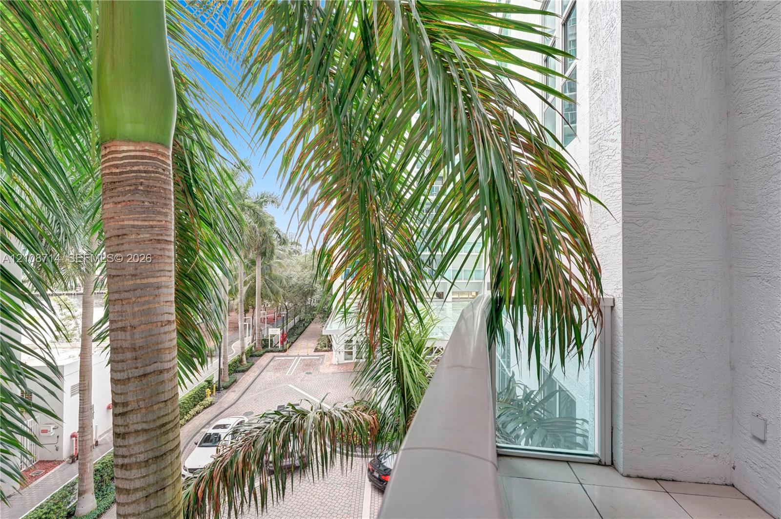Private balcony with tile flooring and a glass-paneled railing