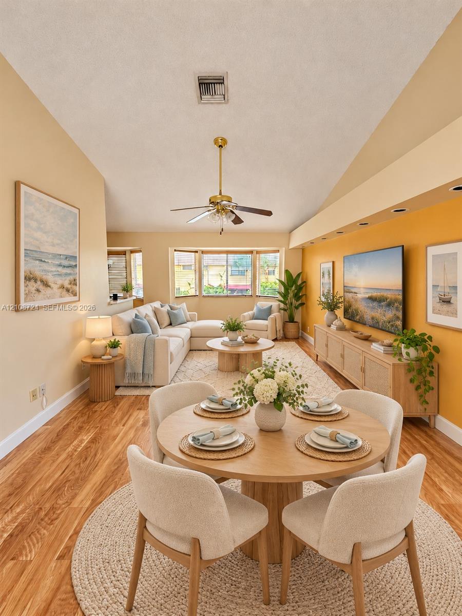 Vaulted ceilings, wood-finish flooring, recessed lighting, and a bay window