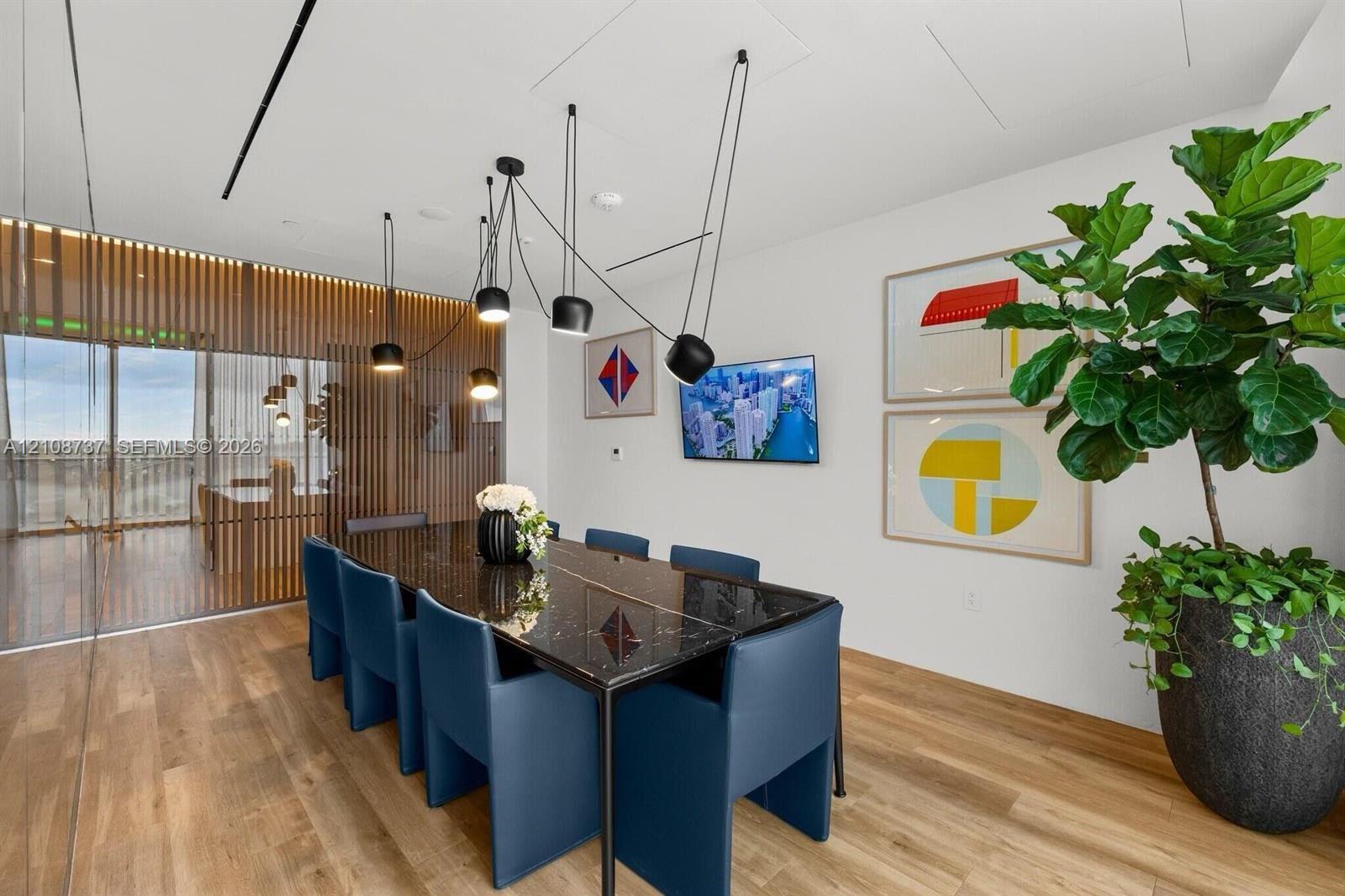 Wood-finish flooring, multi-light contemporary pendant fixture, and decorative wood-slat privacy screen