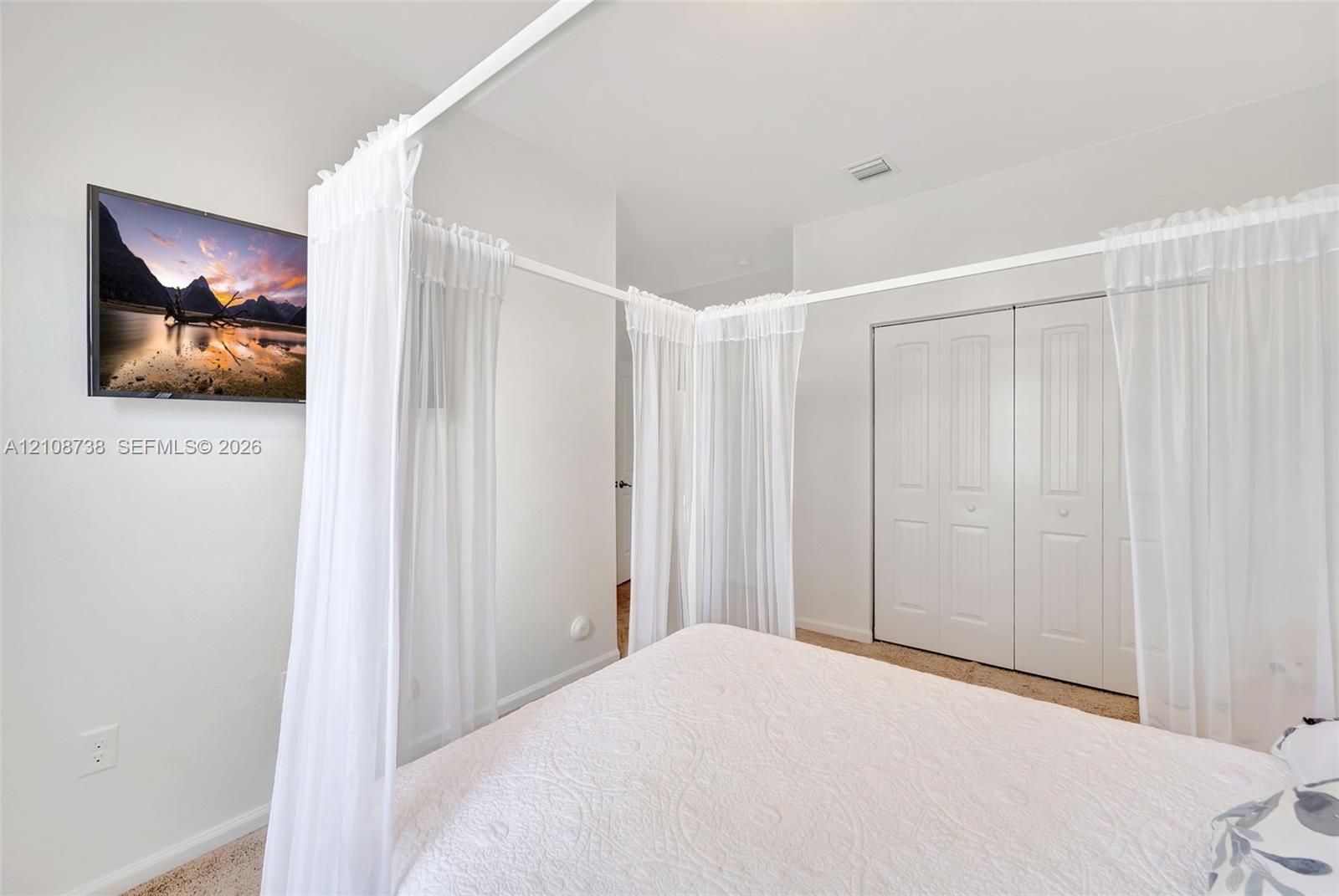 Neutral wall-to-wall carpeting, white interior paint, and sliding double-panel closet doors