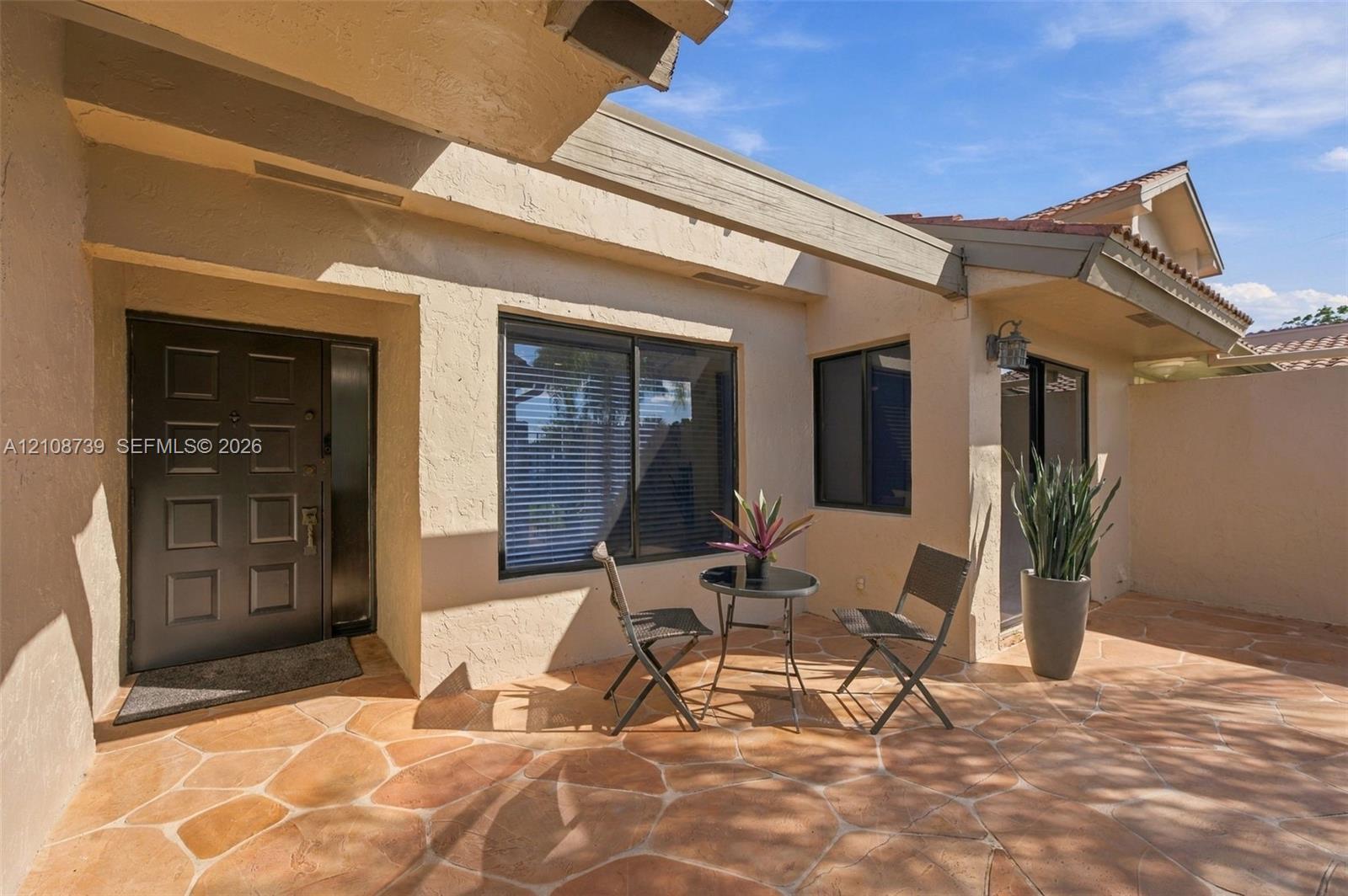 Private courtyard featuring stamped concrete paving, covered entryway, and recessed exterior lighting