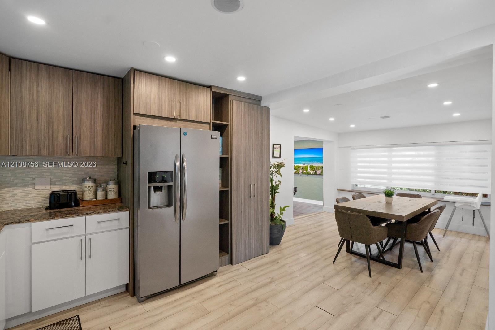 Kitchen featuring wood-finish cabinetry, stainless steel side-by-side refrigerator, stone-surfaced countertops, recessed lighting, and wood-finish flooring