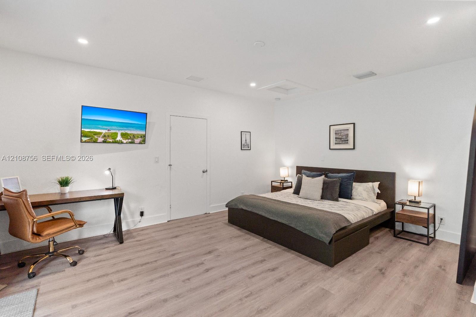 Neutral-toned wood-finish flooring, recessed lighting, and smooth-finish walls
