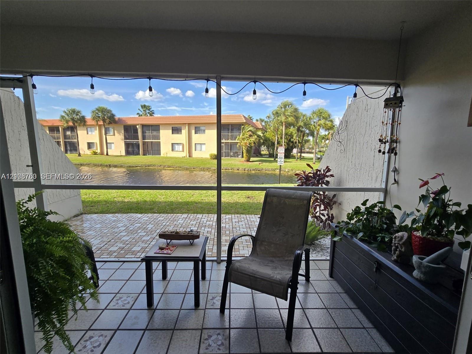 Screen-enclosed patio featuring a ceramic tiled floor and direct access to a waterfront patio area