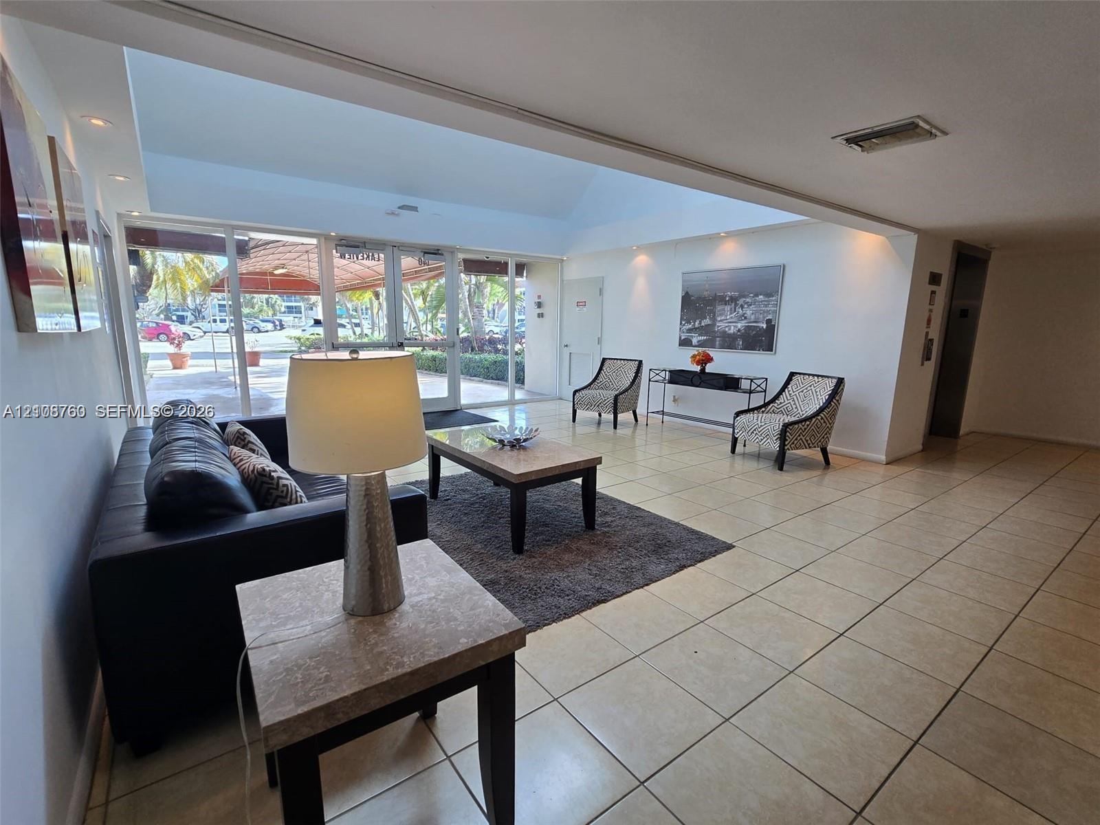 Vaulted ceilings, large-format tile flooring, recessed lighting, and extensive floor-to-ceiling glass entry doors